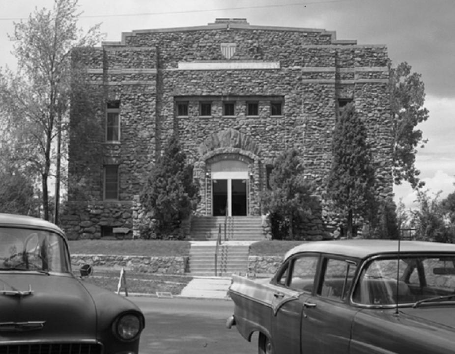 The front of the Armory building on the CU campus with two cars in the foreground.