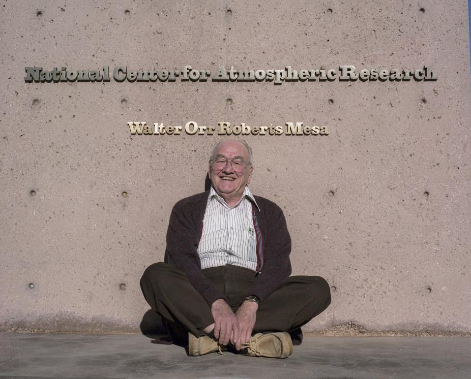 Roberts in 1987 sitting in front of the "Walter Orr Roberts Mesa" sign at the Mesa Lab